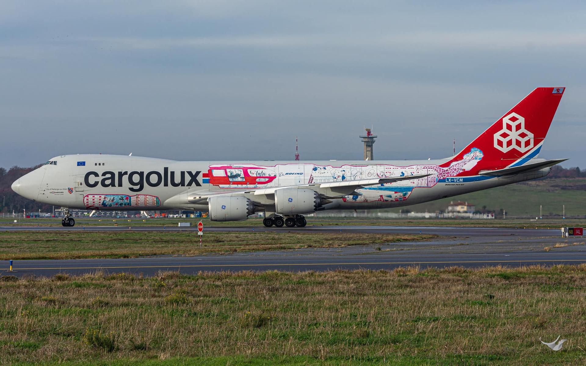 A Cargolux 747-8 painted in the "Cutaway" livery taxiing at an airport.