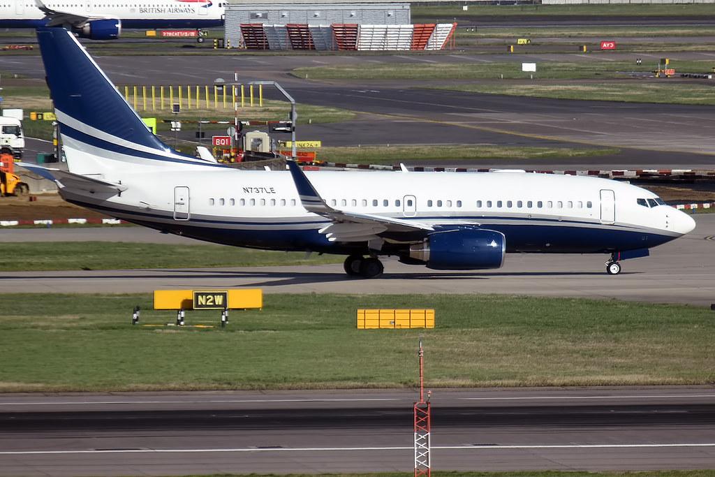 A Boeing BBJ 737-75V with blue and silver accents taxiing at an airport.