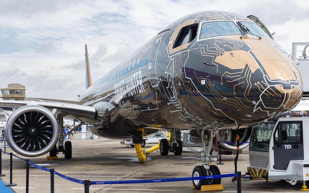 An Embraer E2 in a black and gold livery at a French Air Show.