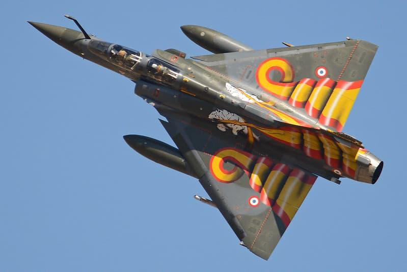 An olive-colored Rafale with two white tigers carrying yellow and red ribbons.