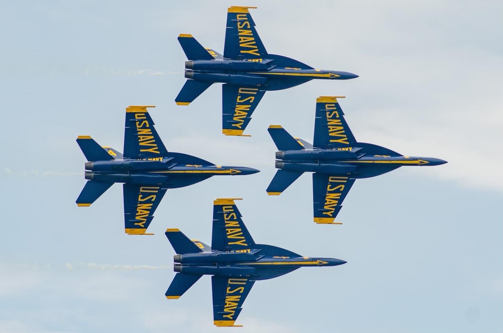 4 Blue Angels flying in formation on a 90 degree bank angle.